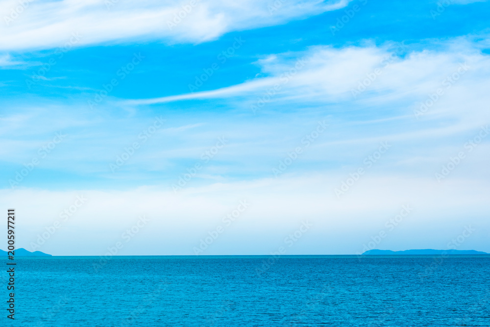 Fototapeta premium Tropical Nature clear sky and summer sea water under a clear blue sky with beautiful clouds and bright sunlight. Perfect for summer vacation and travel background 