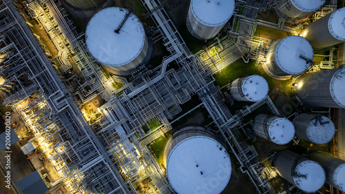 Aerial view oil storage tank and pipeline steel at night, Oil tank storage chemical petroleum petrochemical refinery product, Oil transportation system pipeline steel at oil refinery industry