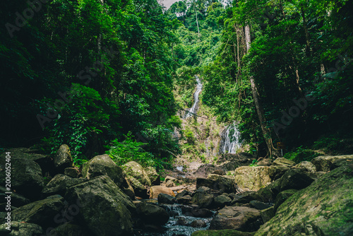 Canvas Print Tropical jungle waterfall flowing through dense rainforest with emerald natural