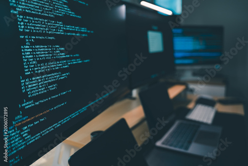 Fotografie Close up of computer monitors displaying source code in a modern workstation wit