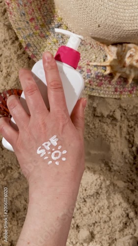 Woman applying white sunscreen lotion on hand with drawing of sun and spf text. Sun protection against uva uvb radiation as prevention of photoaging and skin damage. Summer holiday beach skin care.