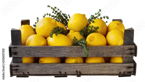 Fotografía Rustic wooden crate overflowing with ripe yellow lemons and fresh green herbs, i