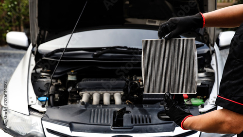 Auto mechanic holding car air conditioner filter for check and clean dirty or fix repair heat have engine problem or replace new change air filter of car care maintenance servicing concepts.
