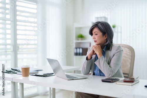 Obraz na plátně Asian businesswoman working laptop computer desk concentrate thinking planning s
