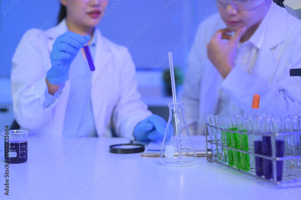 Fototapeta premium Test tubes with green and purple liquid samples in a laboratory rack, symbolizing scientific research, analysis, and experimental chemistry.