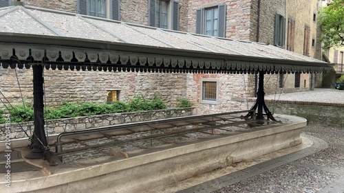 Bergamo, Italy. The old washhouse at the old town. A long white marble basin, subdivided into several parts, with a cast-iron cover and sheet metal plates