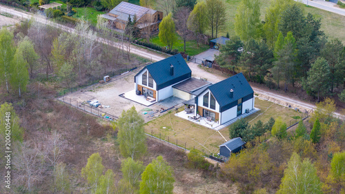 Newly built passive semi-detached family house with shared garage, aerial drone view.