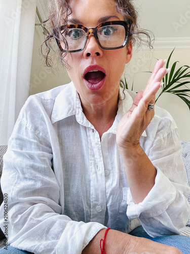 Foto Woman wearing glasses and a white shirt reacting with a shocked, surprised, or a