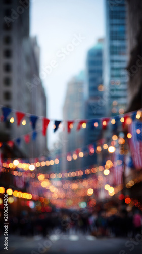 Decorated street with American flags festive banner city buildings blurred lights urban celebration patriotic atmosphere evening downtown outdoor vibrant mood