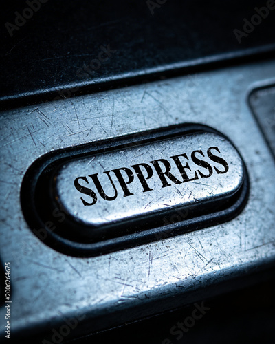Silent control power not speaking metal button with word suppress pressed on scratched surface conveying restraint and tension
