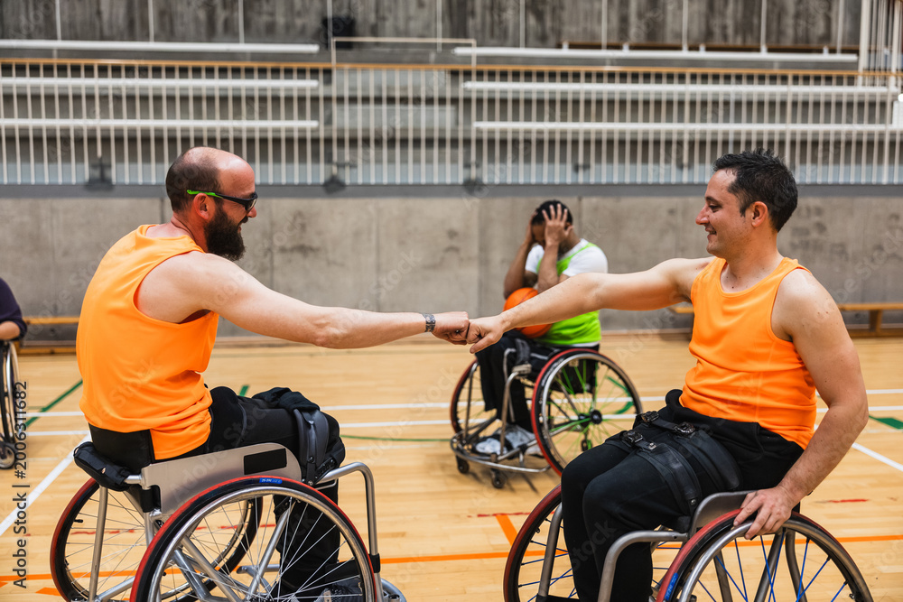 Obraz premium Wheelchair basketball players celebrating a fist bump victory
