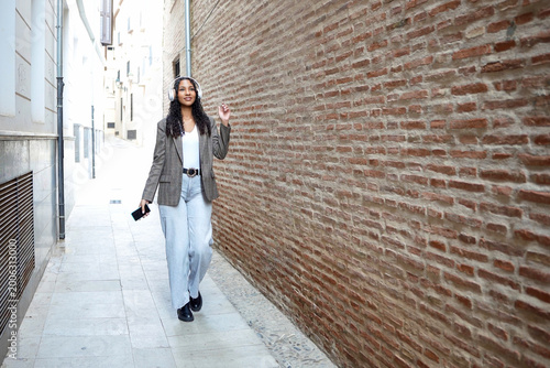 Bild auf Leinwand Trendsetting woman casually posing amidst historic brick surroundings under brig