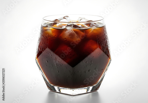 Iced coffee in geometric glass with ice cubes against a white background