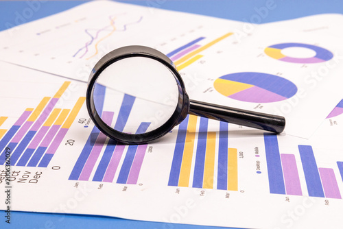 Foto Close-up of a magnifying glass enlarging quarterly data on colorful business charts and graphs