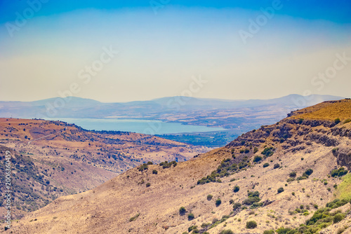 Schilderij op canvas High angle wide shot of arid rocky hills and green bushes in the Golan Heights o