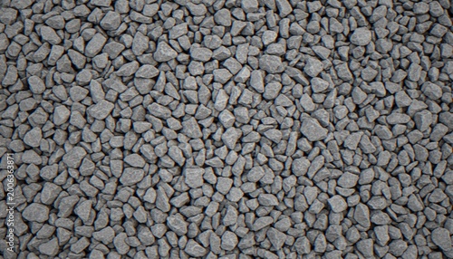 A top-down view of a dense surface covered in small, uniform grey crushed rocks and gravel stones.