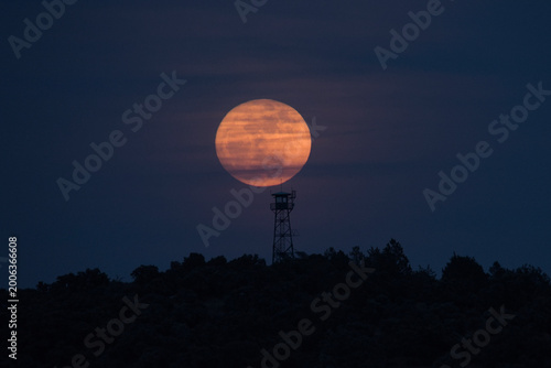 Foto torre de vigilancia forestal con la luna detrás