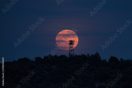 torre de vigilancia forestal con la luna detrás