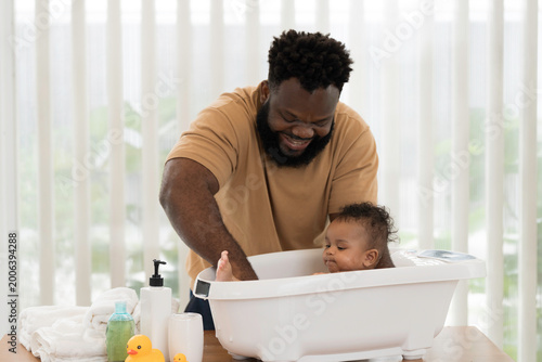 Fotografie Cute baby taking bath in tub of water at home