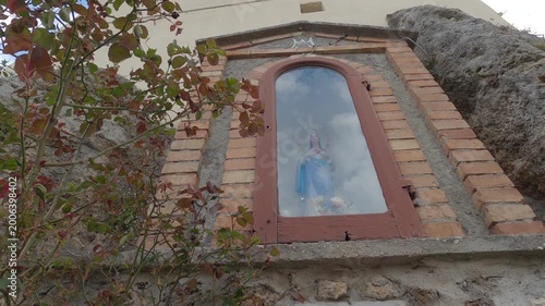 Small statue of the Madonna set in stone, historic center of Castel San Vincenzo, Molise, Italy