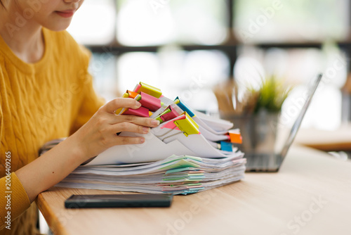 Konstfotografi Woman organizing a stack of documents with colorful binders