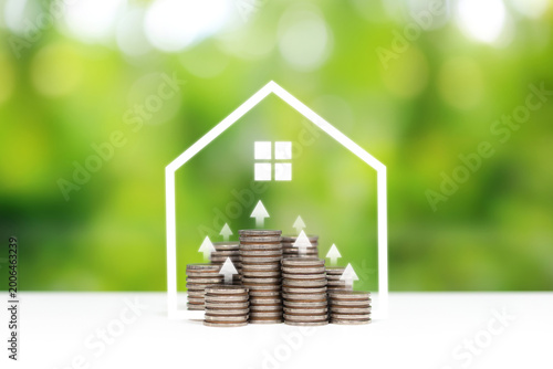 House icon with stacked coins and eco concept background. Sustainable real estate growth with house and coins
