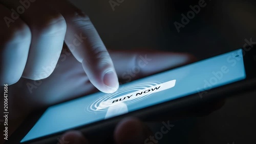 Close up of a finger pressing a glowing digital buy now button on screen