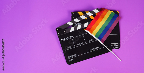 Two Clapper board and rainbow pride flag on purple or violet background.