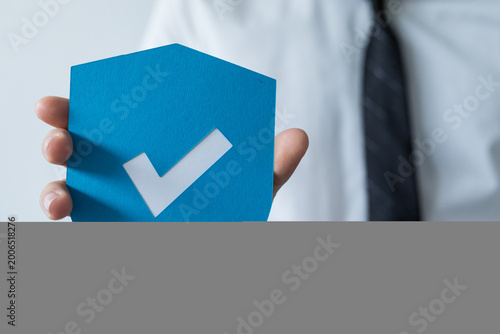 Man in suit holding a blue ...