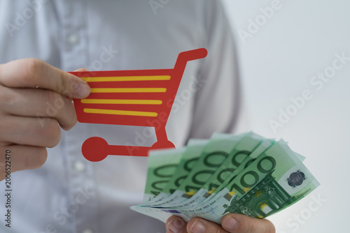 Hand holding shopping cart ...