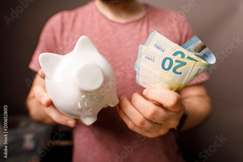 Person putting Euro banknot...