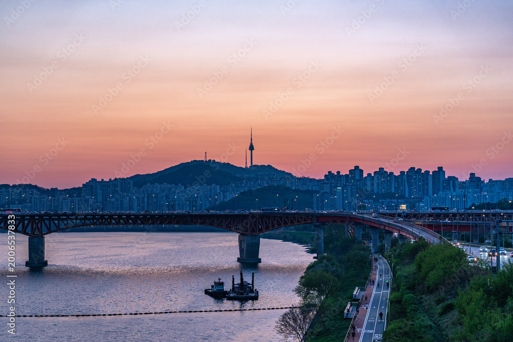 Obraz premium Seoul, South Korea - Apr. 24, 2026 : Sunset Cityscape of Seoul with N Seoul Tower, Seongsu Bridge and Busy Traffic on Gangbyeonbukro Highway