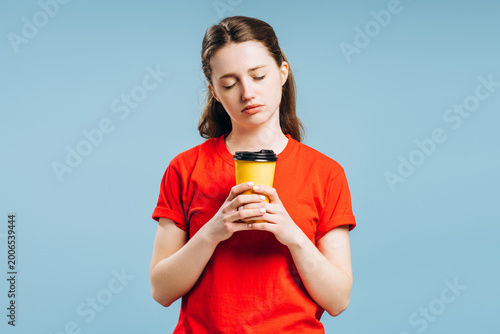 Bild auf Leinwand Tired young woman holding coffee cup needing energy