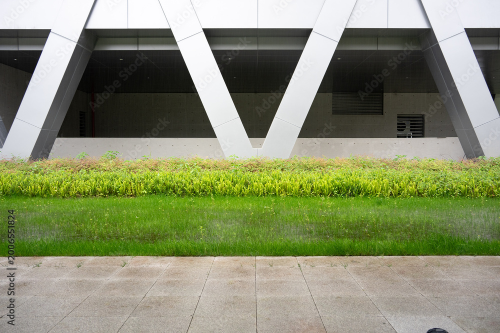 Fototapeta premium Modern architectural geometric structure with green landscaping and clean lines