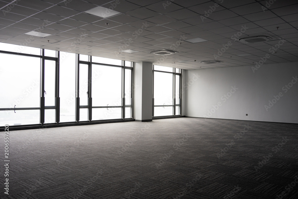 Fototapeta premium Spacious modern office interior with floor-to-ceiling windows and empty carpeted space
