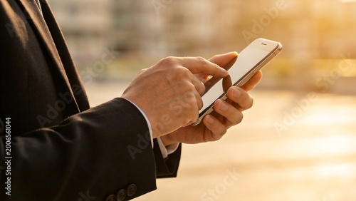 Person in suit using smartphone outdoors
