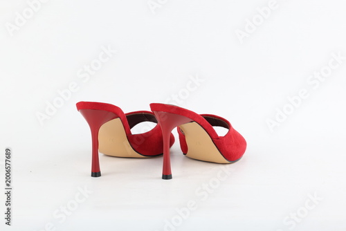 Pair of elegant red high heel mules isolated on white background, clean studio lighting emphasizing shape, texture and modern feminine fashion style with minimal composition