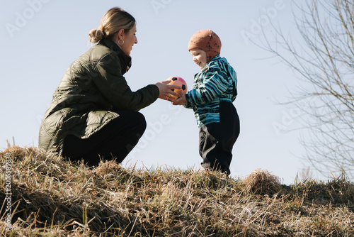 Mother and toddler playing with ball outdoors, family time, parenting, childhood activity and bonding in nature