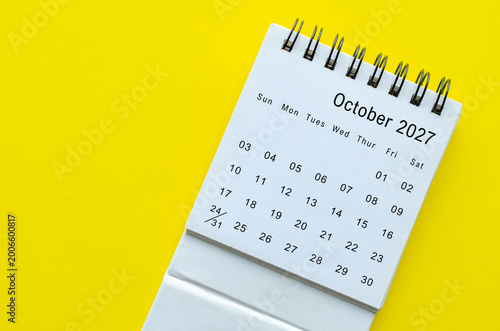 Top view of October 2027 calendar on yellow background with empty space for text.