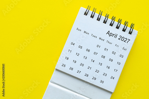 Top view of April 2027 calendar on yellow background with empty space for text.