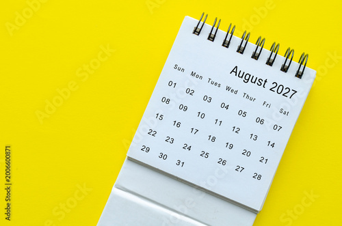 Top view of August 2027 calendar on yellow background with empty space for text.