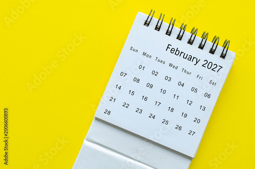 Top view of February 2027 calendar on yellow background with empty space for text.