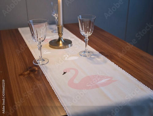 Pink swan table runner set with glassware on wooden table