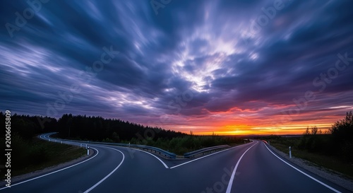 Two divergent paved roads separate under a dramatic cloudy sky at dusk, illustrating the metaphorical choice between different life options, crossroads, destiny, travel
