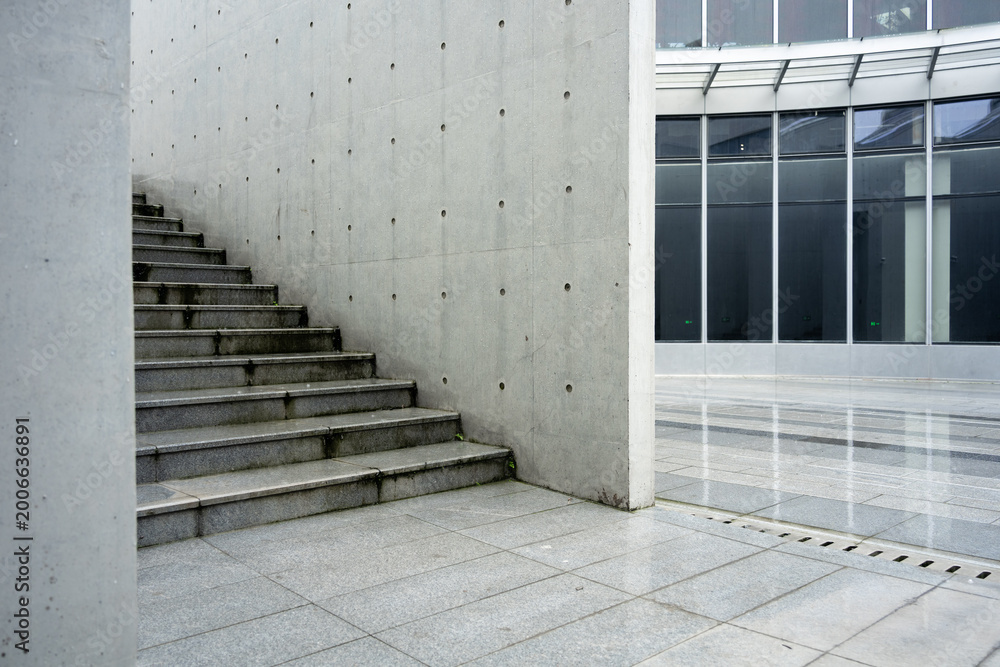 Fototapeta premium Concrete staircase adjacent to glass curtain wall in a modern architectural setting