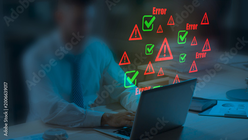 Photos Businessman working on laptop with digital error warnings and check marks, cyber
