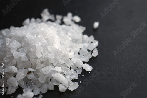 Fényképezés Close-up of a pile of coarse white sea salt crystals on a dark background