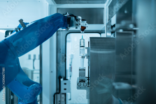 Chemotherapy drug compounding robot with syringe and medicine bottle.Hihg technology pharmaceutical production vaccine concept.New innovation.