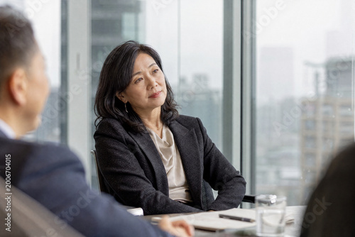 Free Download Senior East Asian Businesswoman Listening Attentively in Meeting - GFXLoad