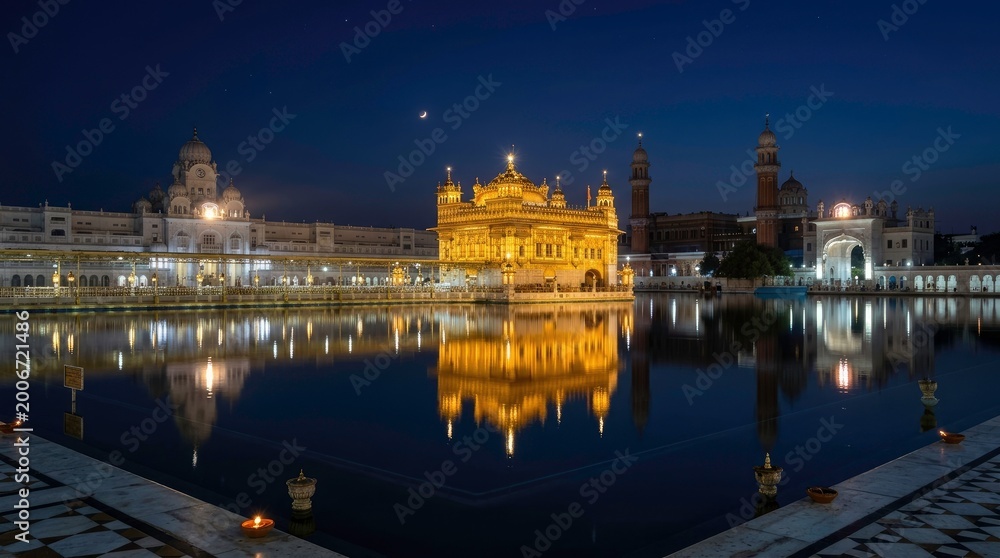 Obraz premium Golden Temple at Night, reflection in water, serene and beautiful scenery.